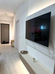 a television on a wall in a living room at Elite Glow Studio in Roşu