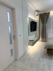 a living room with a door and a television at Elite Glow Studio in Roşu +9 photos
