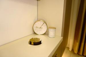 a clock sitting on top of a counter next to a shelf at Elite Glow Studio in Roşu
