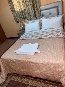 a bed with two white towels on top of it at La paillade in Oulad Barrehil