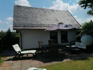 un patio avec une table, des chaises et un parasol dans l'établissement Häuschen in grüner Idylle, à Berggiesshübel