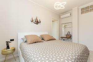 a white bedroom with a bed and a yellow table at Casa Mary 2 - 80 mt dal mare - centro storico in Varazze