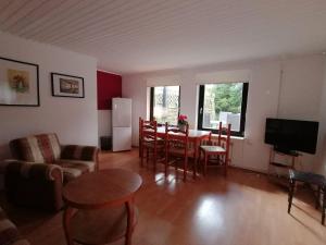 un salon avec une table, des chaises et une télévision dans l'établissement Häuschen in grüner Idylle, à Berggiesshübel