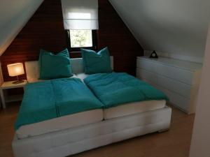 une chambre avec un lit avec des oreillers verts et une fenêtre dans l'établissement Häuschen in grüner Idylle, à Berggiesshübel
