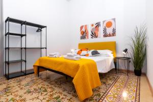 a bedroom with a bed with a yellow blanket on it at Fardella Hospitality in Trapani