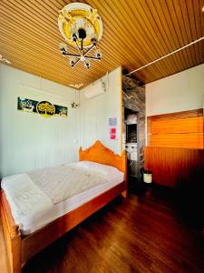 a bedroom with a bed and a chandelier at Nhà Nghỉ Đại Lý Bình Châu in Xuyên Mộc