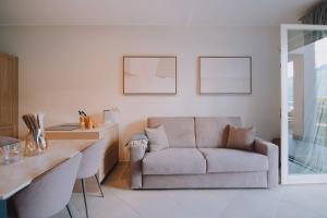 ムッソにあるExclusive Garden Apartment with Lake View & Poolのソファとテーブルのあるリビングルーム
