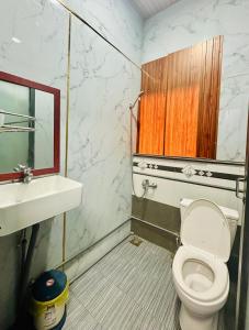 a bathroom with a toilet and a sink and a mirror at Nhà Nghỉ Đại Lý Bình Châu in Xuyên Mộc +41 photos