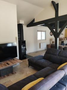 a living room with a couch and a tv at Villa Les Combes avec piscine chauffée in Proissans