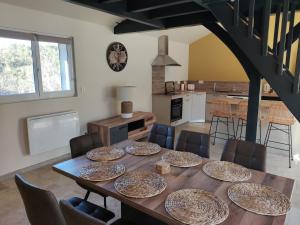 a dining room with a table with plates on it at Villa Les Combes avec piscine chauffée in Proissans