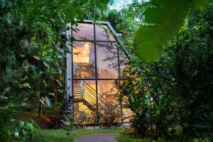 坦加拉Hiriketiya Tropical Hideaway - Hazeloft Tangalle的玻璃房子，窗户上有倒影