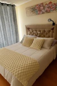 Un dormitorio con una gran cama blanca con dos almohadas. en Antofagasta Centro 2 habitaciones, en Antofagasta