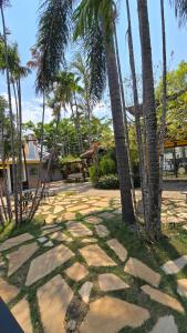 a stone walkway with palm trees in a yard at Hotel Flores de Holambra in Holambra