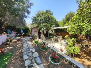 a garden with flowers and a stone path at Glyfada Bay Studios in Varlamaíika