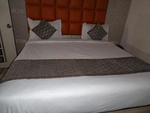 a large bed with white sheets and pillows at Hotel Rohan International in Jāmb