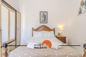a bedroom with a bed with a home holidays sign on it at #237 Vivenda Lilia by Home Holidays in Albufeira +44 photos