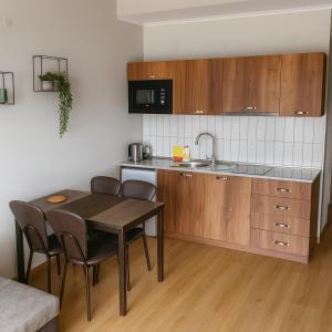cocina con mesa de madera, sillas y encimera en Alpine Vista Gudauri, en Gudauri