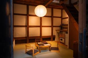a room with a table and chairs and a lamp at Tokinoma ときのま in Kawagoe