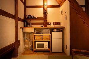 a small kitchen with a microwave and a refrigerator at Tokinoma ときのま in Kawagoe