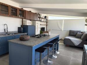 a kitchen with a blue island in a living room at Cobertura na Praia Grande in Praia Grande
