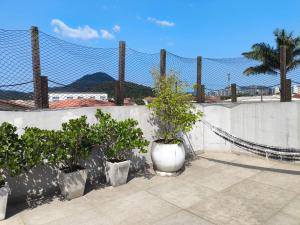a fence with three potted plants on a patio at Cobertura na Praia Grande in Praia Grande +3 photos
