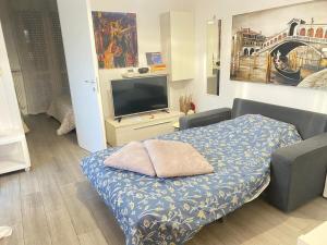 a living room with a bed and a tv at Casa Clara in Altavilla Vicentina