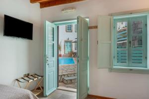 a bedroom with a door open to a pool at Santanna Suites in Patmos