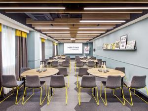 a conference room with tables and chairs and a screen at Novotel London Bridge in London