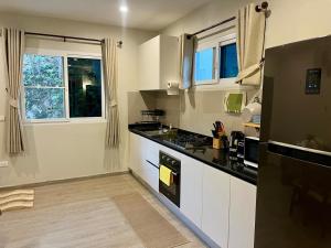 a kitchen with white cabinets and a black counter top at Lanta Sunshine Residence Apt 4 Two Bed Apartment with AC and Work Space in Ko Lanta
