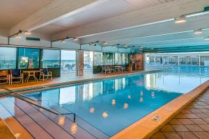 a large swimming pool with tables and chairs in a building at Pinnacle Port C2-404 in Panama City Beach