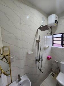 ベニンシティにあるShort Let Apartment in Benin City- Hosted By Tomlaのトイレと洗面台を備えた白いバスルーム +10枚の写真