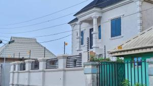 ベニンシティにあるShort Let Apartment in Benin City- Hosted By Tomlaの前に柵がある白い建物