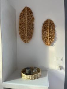 a white wall with two baskets on a shelf at The Dream in Ios Chora