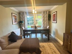 a living room with a table and a couch at Family-Friendly 4BR Home in Sale, Manchester - Garden & Double Driveway in Sale