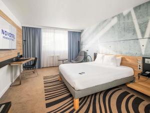 una habitación de hotel con una cama y un escritorio en Novotel Kraków City West, en Cracovia