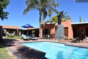 a swimming pool in front of a house at Culdesac Guesthouse Oudtshoorn in Oudtshoorn