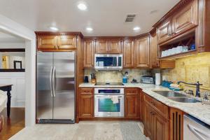 a kitchen with wooden cabinets and a stainless steel refrigerator at Misty Morning in Sugar Mountain
