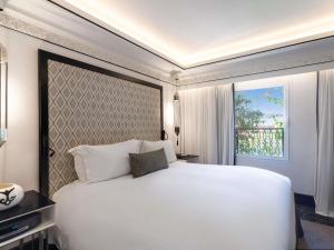 a bedroom with a large white bed and a window at Sofitel Marrakech Palais Impérial & Spa in Marrakech