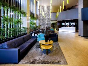 a lobby with a couch and a table and plants at Grand Mercure Brasilia Eixo Monumental in Brasilia