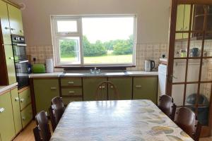 a kitchen with a table with chairs and a window at 5 Bed House Sleeps 10 - 40 Minutes from Dublin in Summerhill