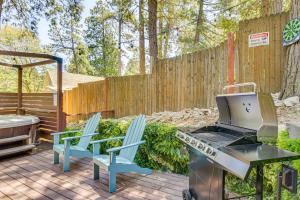 a patio with two chairs and a grill and a fence at Private Hot Tub! Cozy Crestline Cabin 1 Mi to Lake in Crestline