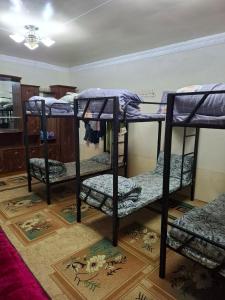 una habitación con tres literas en una habitación en Lucky Hostel oilaviy korxona, en Yakkasaray
