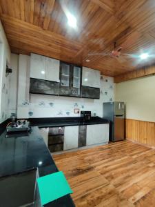 a kitchen with a refrigerator and a wooden ceiling at Khaapus Home Naggar in Nagar +28 photos
