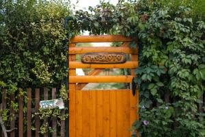 a wooden gate with a plant on top of a fence at Бунгала Гнездото Bungalows The Nest 1 in Lozenets