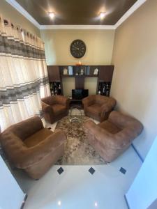 a living room with couches and a clock on the wall at Seventh Heaven Villa in Hakgala +17 photos