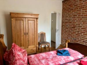 a bedroom with a bed and a chair and a cabinet at Eulenwohnung Apartment in Gommern