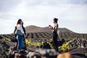 two women standing in a field looking at their cell phones at Hotel EL GRIFO in San Bartolomé +71 photos