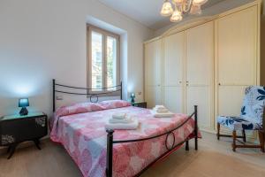 a bedroom with a bed and a chair in it at Illy House Apartment in Alghero