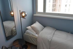 Una pequeña habitación con una cama y un espejo. en Penthouse Kemi, en Kemi