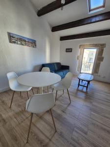 uma sala de estar com uma mesa, cadeiras e um sofá em LE MARIUS 2 PIECES 4 personnes Coeur de ville em Mèze